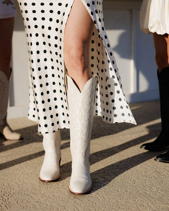 woman standing in white  boots